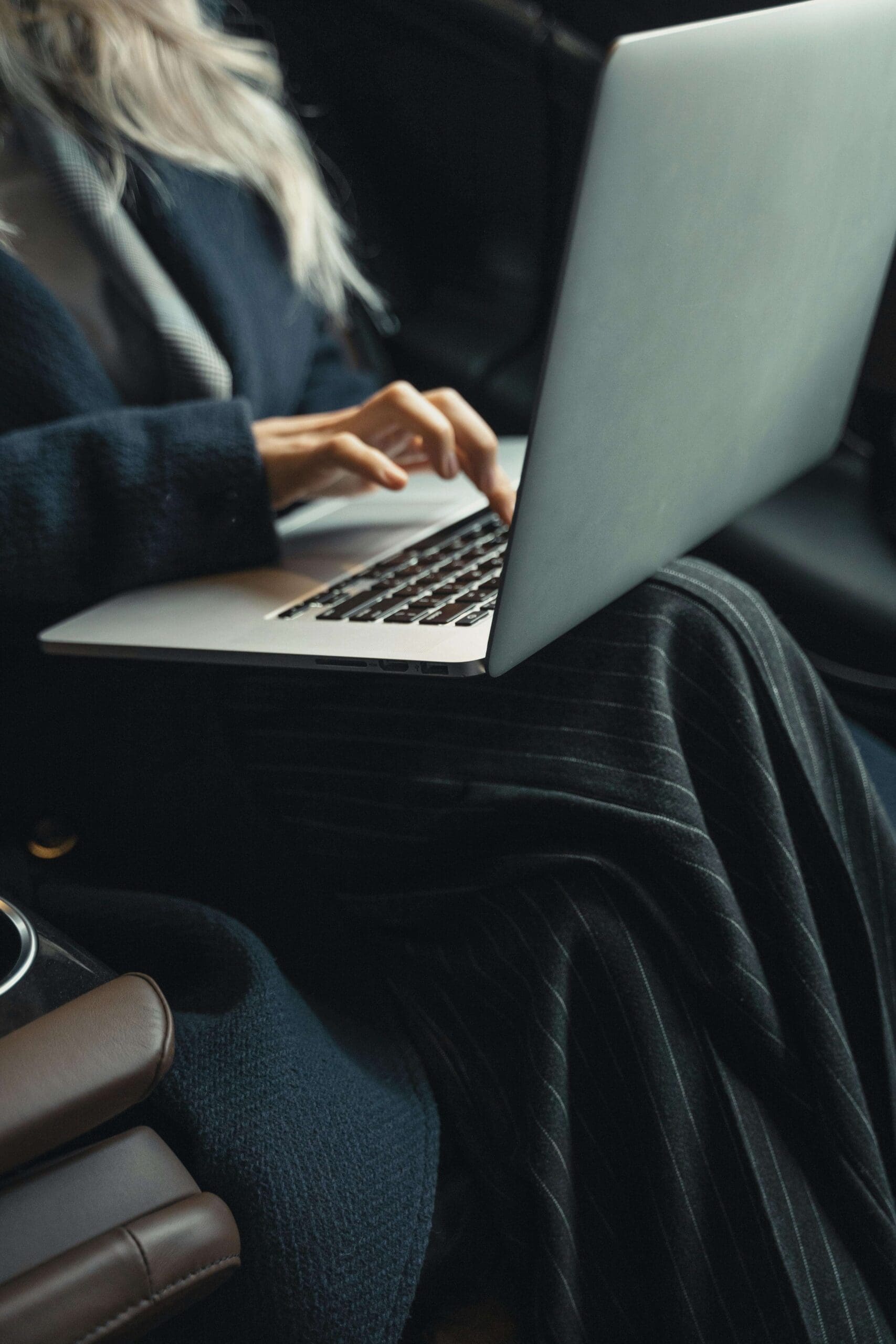A blonde woman types on a laptop while wrapped in cozy dark layers. Could trauma be driving the codependent patterns showing up in your relationships? Relational trauma therapy in Palm Beach, FL, can help you find answers.