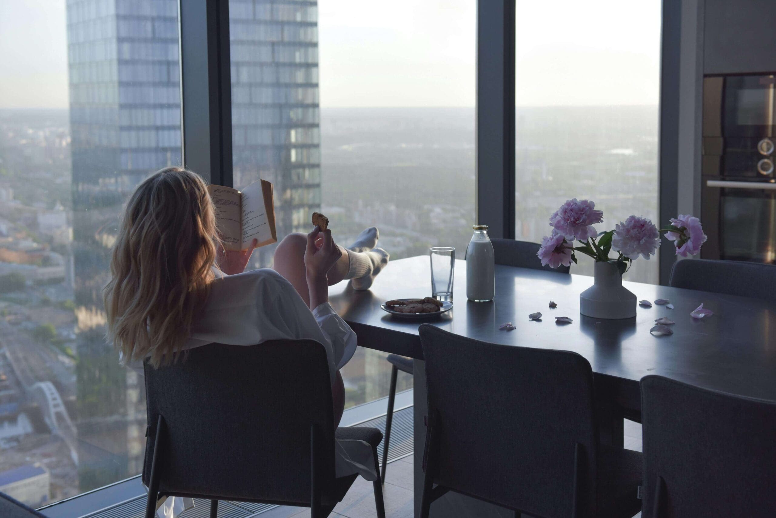 A woman reads by a window with a city skyline view. Do you find it hard to enjoy quiet self-care moments without feeling like you should be doing more? A relational trauma therapist in Palm Beach, FL can help you heal the beliefs behind that restlessness.