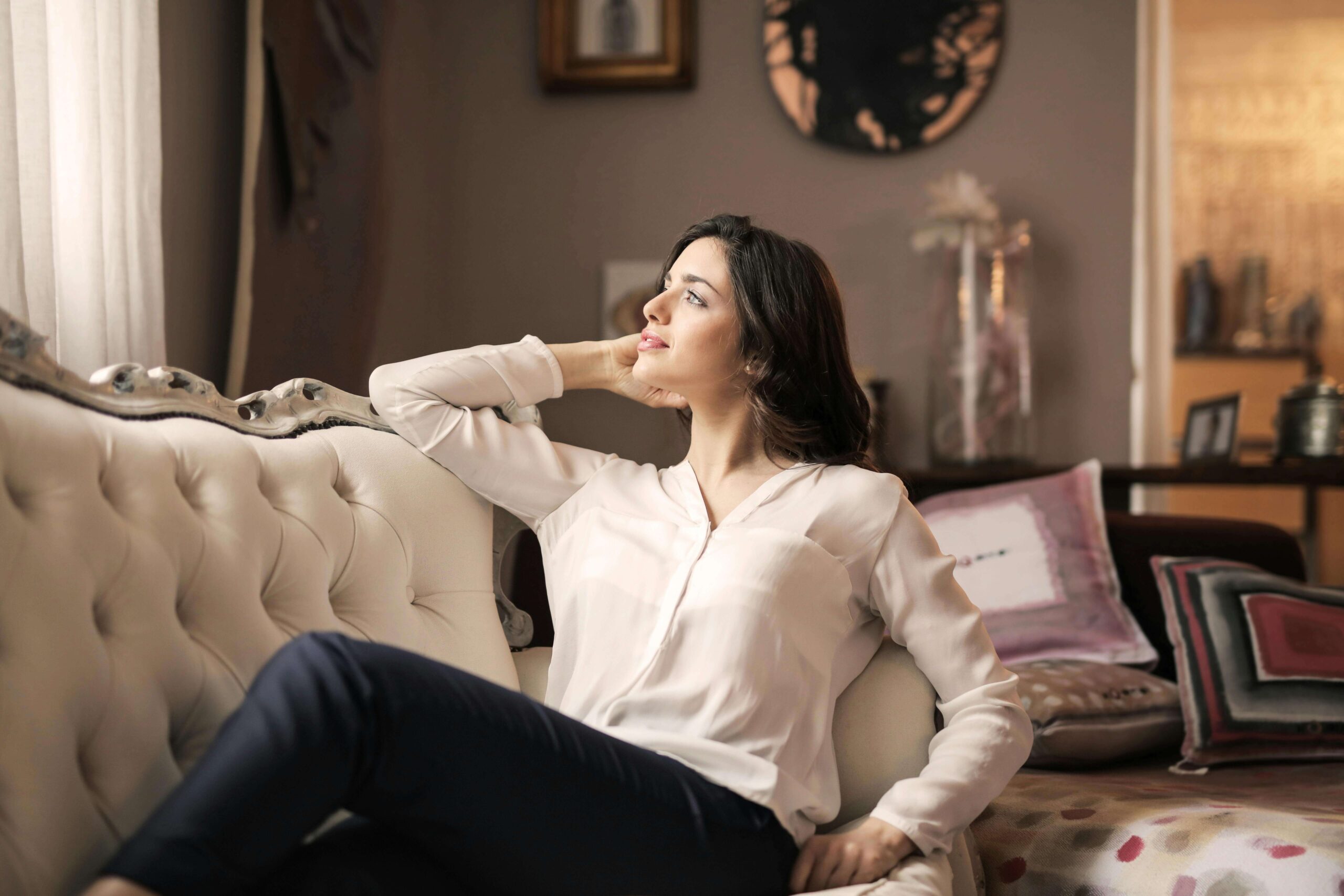 A woman reclines on an elegant sofa. Does overworking feel safer than resting because slowing down brings up feelings you'd rather avoid? A relational trauma therapist in Palm Beach, FL can help you finally feel at ease in moments of stillness.