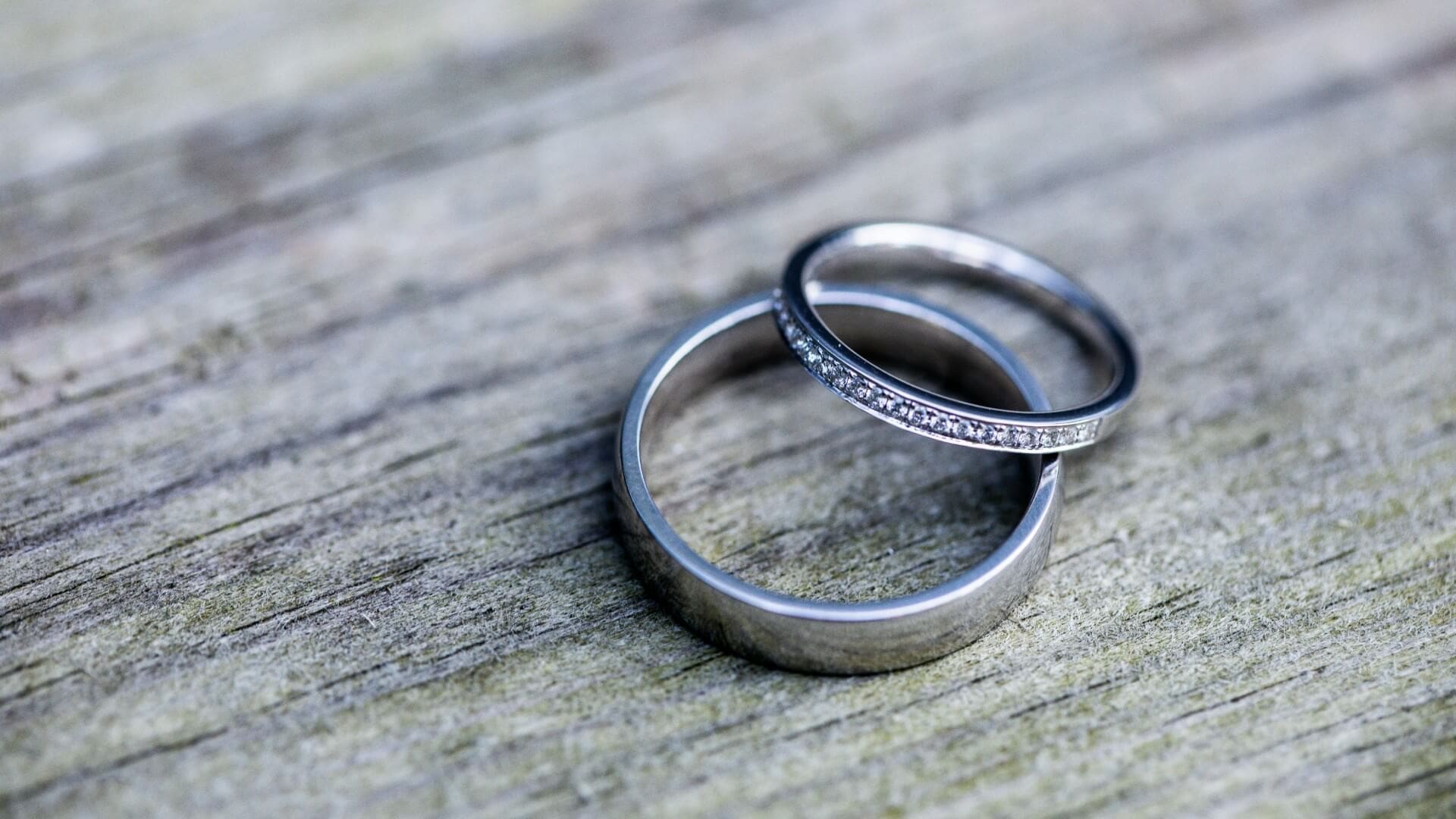 Two silver wedding bands rest on weathered wood. Has betrayal in your closest relationship left you questioning everything you believed to be true? Relational trauma therapy in Palm Beach, FL, can help you grieve, heal, and rediscover who you are beyond the betrayal.