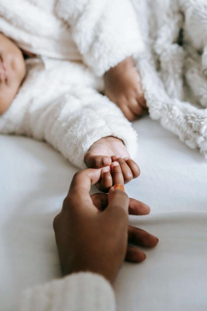 Tiny hand | parenting with unhealed relational trauma palm beach | relational therapy for trauma | complex relational trauma | Palm Beach, Florida | Jupiter | Palm Beach Gardens | Wall Street South | Whitehall A parent gently holds the tiny hand of a sleeping newborn. Is unhealed trauma influencing the way you connect with your child? A relational trauma therapist in Palm Beach, FL, can help you process your past so you can be fully present for your little one.