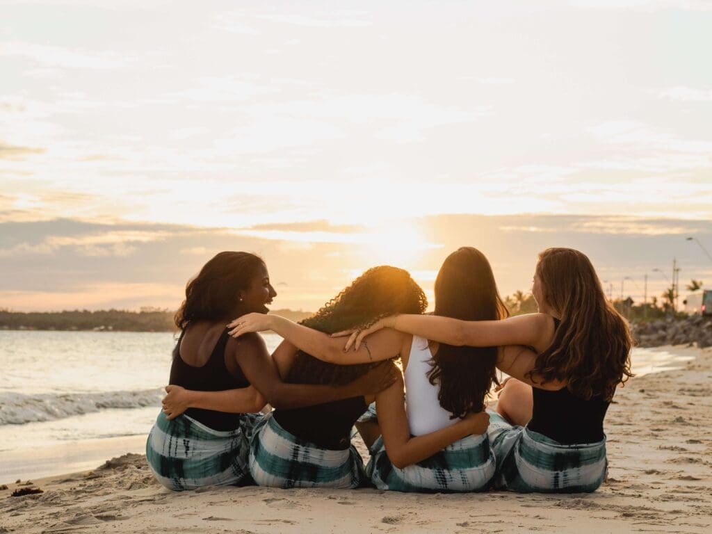 Beach women | summer happiness palm beach | complex ptsd online therapist palm beach, fl | relational trauma therapy | Palm Beach, Florida | Wellington | Boynton Beach | The Island | The Colony Hotel Four women sit on a beach at sunset. Are you surrounded by people this summer yet still struggling to feel genuine happiness or a sense of belonging? Relational trauma therapy in Palm Beach, FL, can help you heal those deeper wounds.