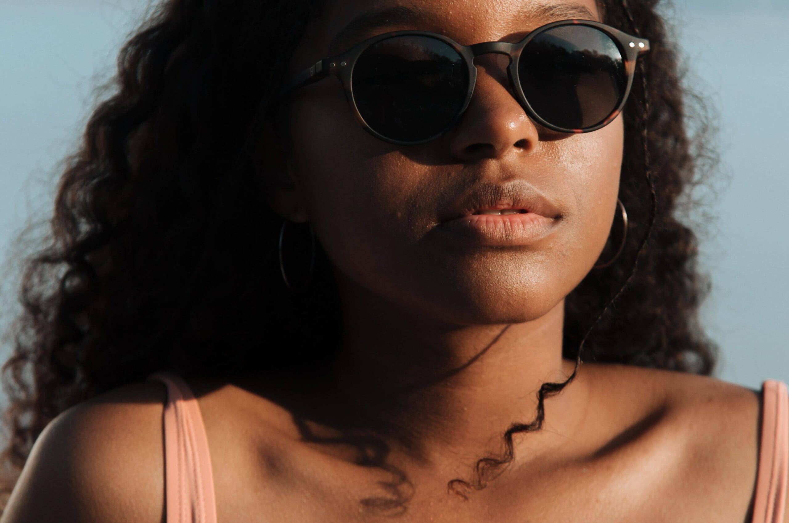 Close-up of a woman wearing sunglasses bathed in warm summer light. Are you going through the motions of summer while feeling emotionally disconnected from the joy everyone around you seems to have? A relational trauma therapist in Palm Beach, FL, can help.