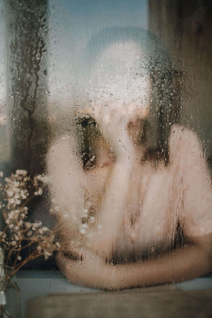 Rainy window | online relational trauma therapist palm beach | trauma therapy for high achievers palm beach | relational trauma therapy | Palm Beach, Florida | Jupiter | Palm Beach Gardens | Wall Street South | Whitehall A blurred silhouette is seen through a window covered in rain droplets. What does it feel like when there's no margin left for yourself? An online relational trauma therapist in Palm Beach, FL can help you find clarity again.